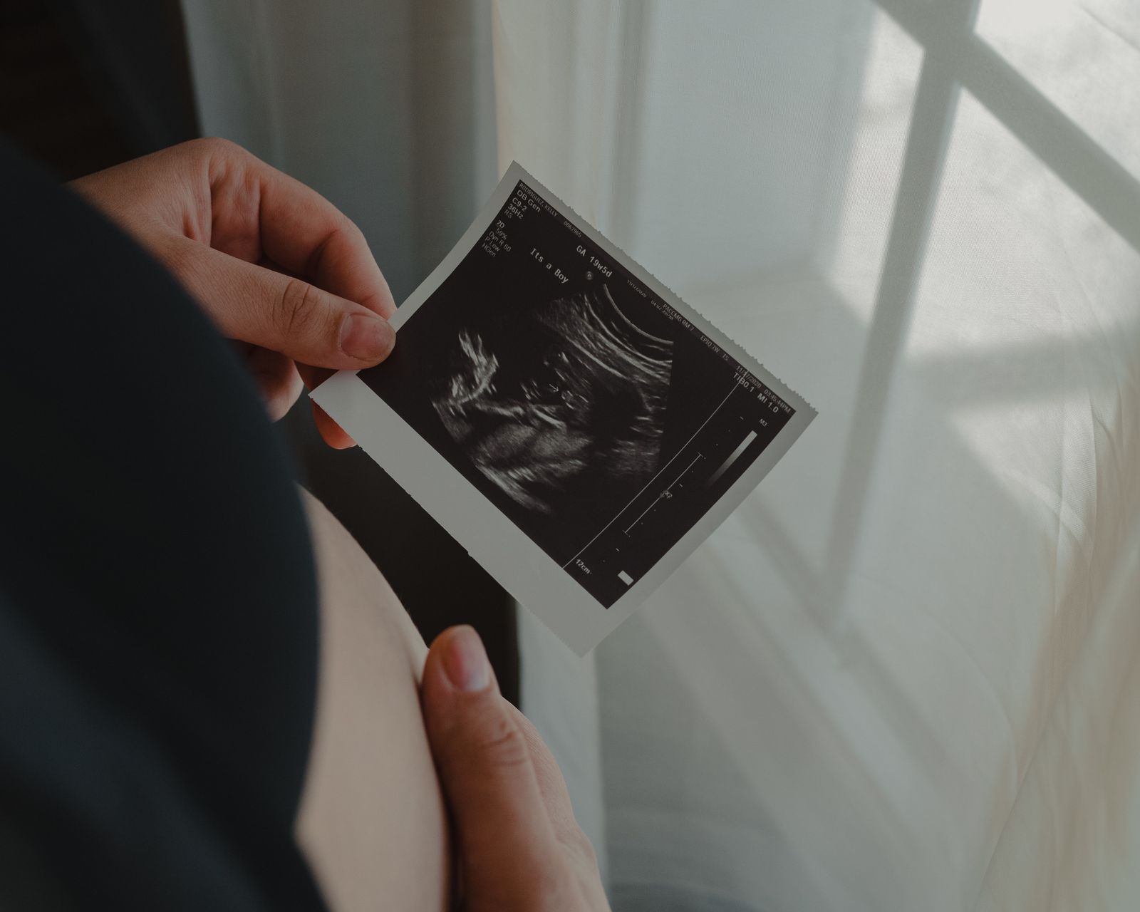 Une femme enceinte tenant une image d’échographie